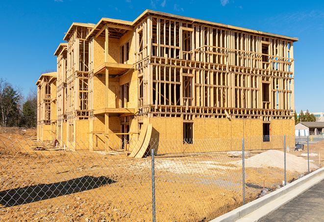 a temporary chain link fence in front of a building under construction, ensuring public safety in Southwest Ranches